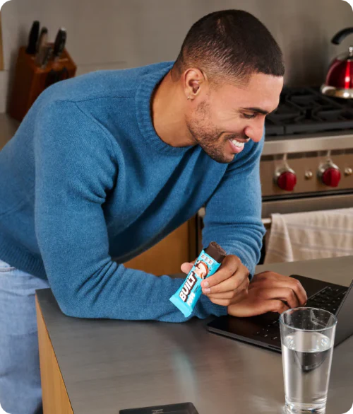 Man working on a laptop while eating a BUILT Puff